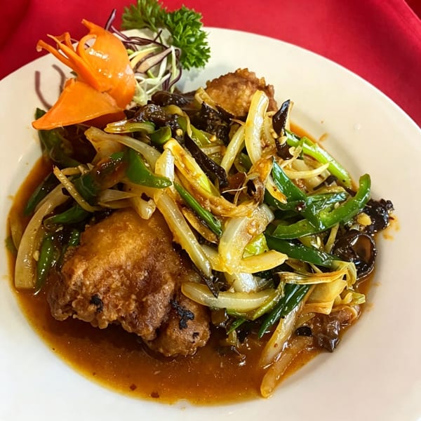 Crispy fried chicken with stir-fried green peppers, onions, and wood ear mushrooms in a savory sauce.